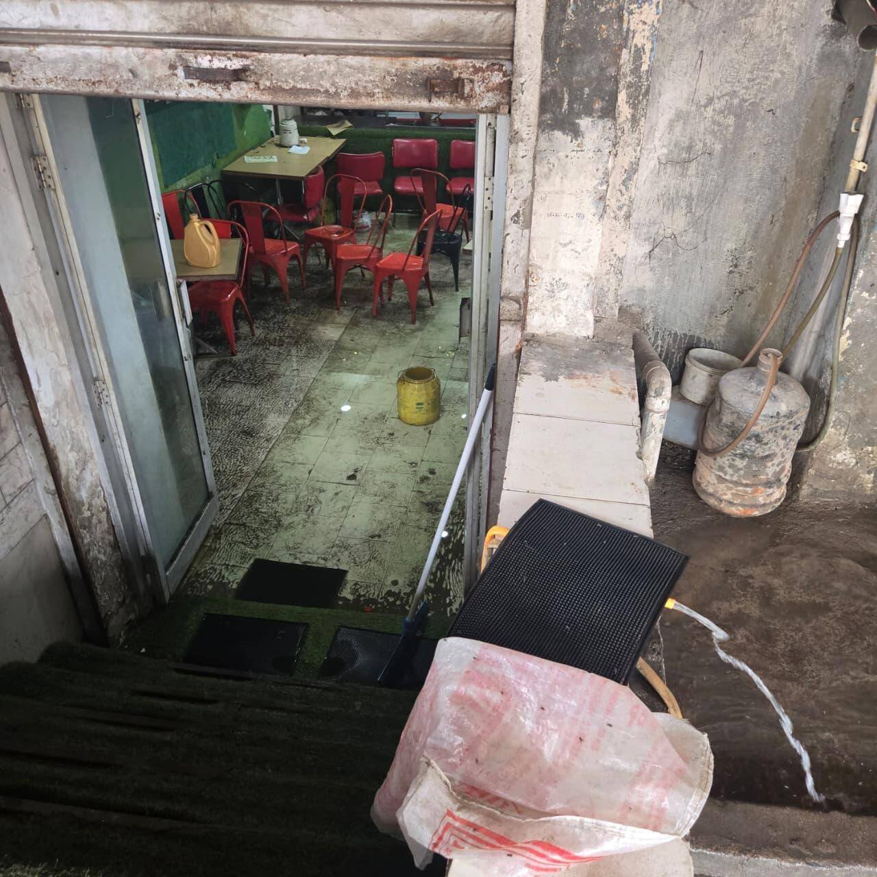 Barred by elevated pavement, rainwater parks on road